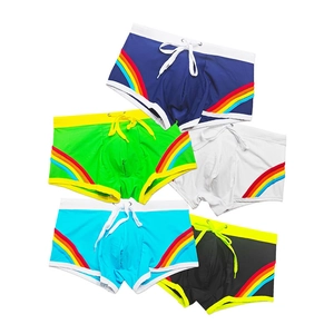 Flat lay of men's square-cut swim trunks set featuring rainbow stripes and drawstring waist