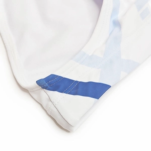 Gros plan des coutures et des motifs géométriques bleus sur le slip de bain blanc