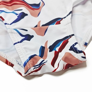 Close-up of double-needle stitching on white printed swimwear with abstract pattern