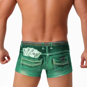 Detail view of men's green denim-print swim trunks featuring creative US dollar graphics