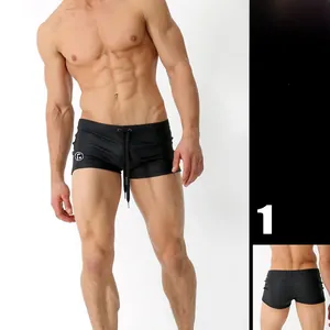 Detail view of men's black swim trunks showing waist drawstrings and athletic fit fabric