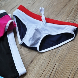 Men's navy blue and white patchwork swim trunks with red waistband and drawstring detail