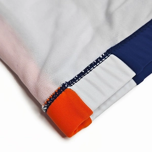 Dettaglio delle cuciture del tessuto elastico con pannelli laterali blu e arancioni