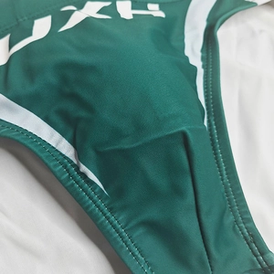Détail du slip de bain vert foncé pour homme avec rayures blanches et tissu élastique