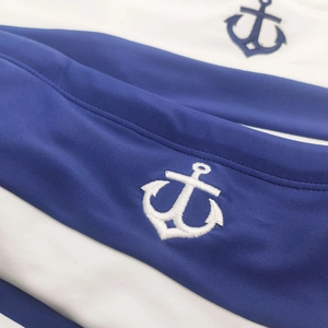 Detail of blue and white striped swimwear with high-quality white anchor embroidery