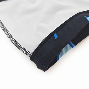 Detailed close-up of flatlock stitching on the hem of printed athletic swim trunks