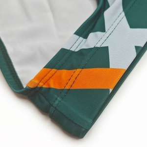 Détail du maillot de bain vert avec motif d'étoiles, bandes oranges et coutures plates