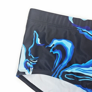 Detailed macro view of men's quick-dry swim shorts with blue ocean wave print and lining