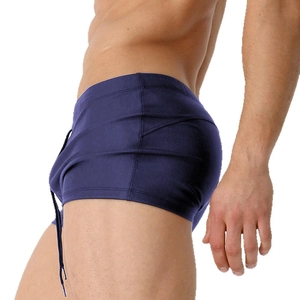 Navy blue men's tight swimming trunks with elastic drawstring waist on white background