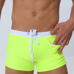Detail of neon yellow men's swim trunks with white drawstring and side pocket