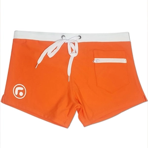 Detail of orange swim trunks featuring a side zipper pocket and white drawstring waistband