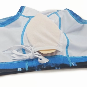 Close-up of men's swim trunks featuring tie-dye print and inner protective cup pocket
