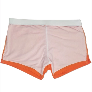 Detailed view of men's swimming trunks featuring contrast orange trim and white elastic waist