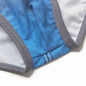 Detail view of denim print swim briefs featuring grey piping and durable double-stitch seams
