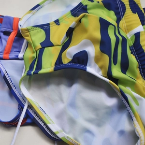 Close-up of men's camo swim briefs with vibrant prints and elastic drawstring waistband