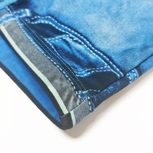 Detail of the denim-printed texture and reinforced double-row stitching on the swim trunks