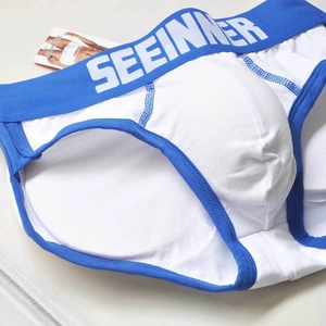 Dettaglio slip da uomo in cotone bianco con elastico blu in vita e cuciture sulla tasca