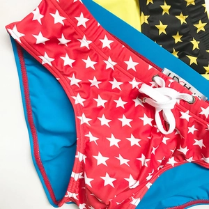 Detail of men's swim briefs with star prints, drawstring waist, and metal eyelets