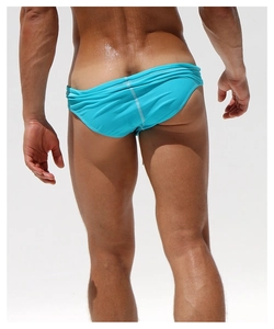 Rear view of men's lake blue low waist swim trunks showing fabric fit and athletic cut