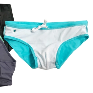 Detail view of turquoise men's swim briefs with white drawstring and side metal eyelet