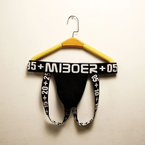 Close-up of black cotton jockstrap with black and white elastic waistband on a hanger