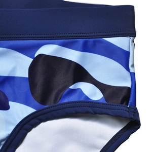 Macro view of blue camouflage men's swim briefs showing elastic waistband and stitching