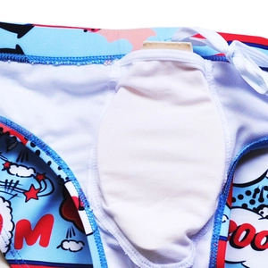 Detail of cartoon print men's swim trunks featuring a secure white drawstring and inner pouch