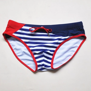 Flat lay of men's nautical striped swim trunks with red contrast drawstring and pouch