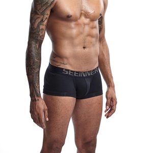 Detail showing wide elastic waistband with gray brand logo on black cotton boxer shorts