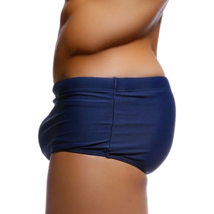 Side view of dark blue nylon swim trunks showing tight fit and elastic waistband
