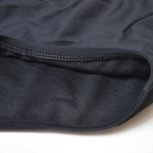 Macro detail of high-quality double-stitch seams on black nylon swimming trunks