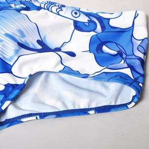 Vue détaillée du short de bain pour hommes avec imprimé océan bleu et blanc et coutures nettes