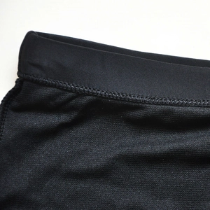 Close-up of men's black swim trunks featuring elastic waistband and durable knit texture
