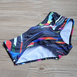 Men's square-cut swim trunks with colorful geometric abstract prints on black fabric