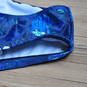 Detailed close-up of tropical palm leaf print swimwear with secure rolled-edge stitching