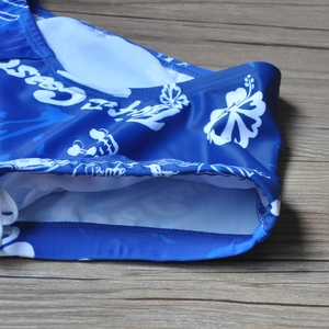 Close-up of navy blue men's swim trunks featuring white floral print and soft inner lining