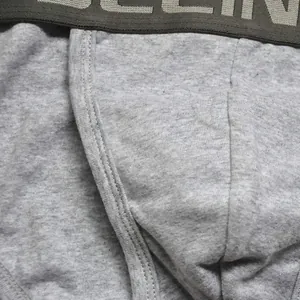Close-up of men's cotton briefs showing gray elastic waistband and reinforced seams