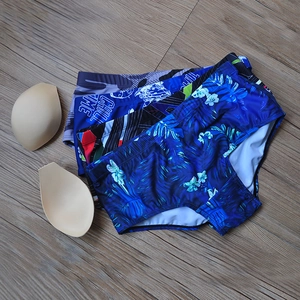 Detail view of tropical leaf and geometric print swim trunks with removable sponge pads