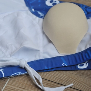 Detail of blue men's swim trunks featuring a removable protective pad and white drawstring