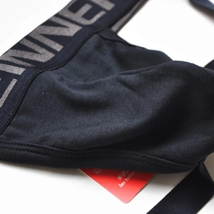 Détail de jockstrap en coton noir avec large ceinture élastique et logo texturé
