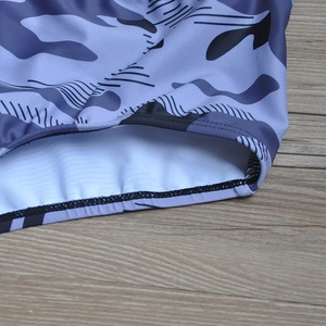 Detail of men's grey camo swim trunks showing reinforced stitching and blue lining fabric