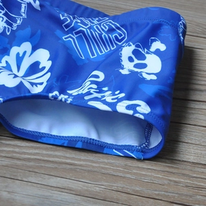 Détail du maillot de bain bleu pour hommes avec fleurs tropicales blanches et imprimés