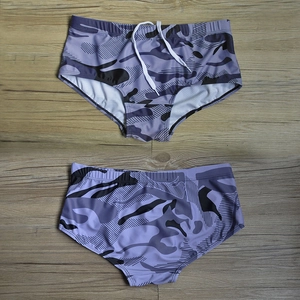 Front and back view of men's gray camouflage swimming trunks with white drawstring waist