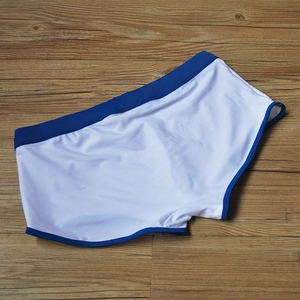 Maillot de bain blanc pour homme avec bordure bleu marine sur fond de bois naturel