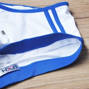 Détail du maillot de bain blanc avec rayures bleues et cordon à embouts métalliques