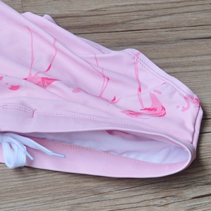 Close-up of pink flamingo print swimwear fabric with white drawstring detail