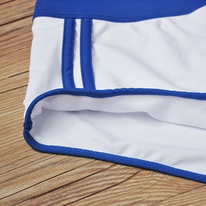 Détail du maillot de bain blanc pour hommes avec bandes bleues et coutures de précision