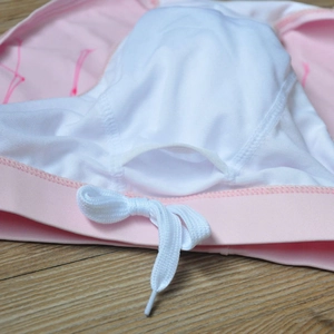 Detail view of pink swim trunks featuring white mesh lining and adjustable drawstring