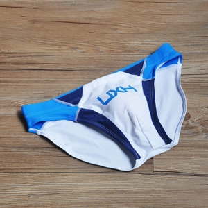 Detailed flat lay of men's low rise swim briefs featuring blue and white patchwork design