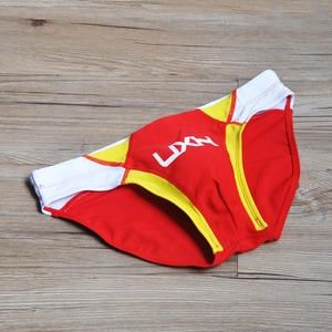 Detail of men's low-rise swim briefs with red, yellow, and white patchwork design